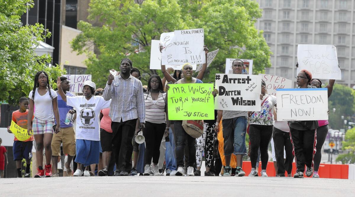 Protesters march outside the Buzz Westfall Justice Center in Clayton, Mo., where the grand jury is convening in the Michael Brown case.