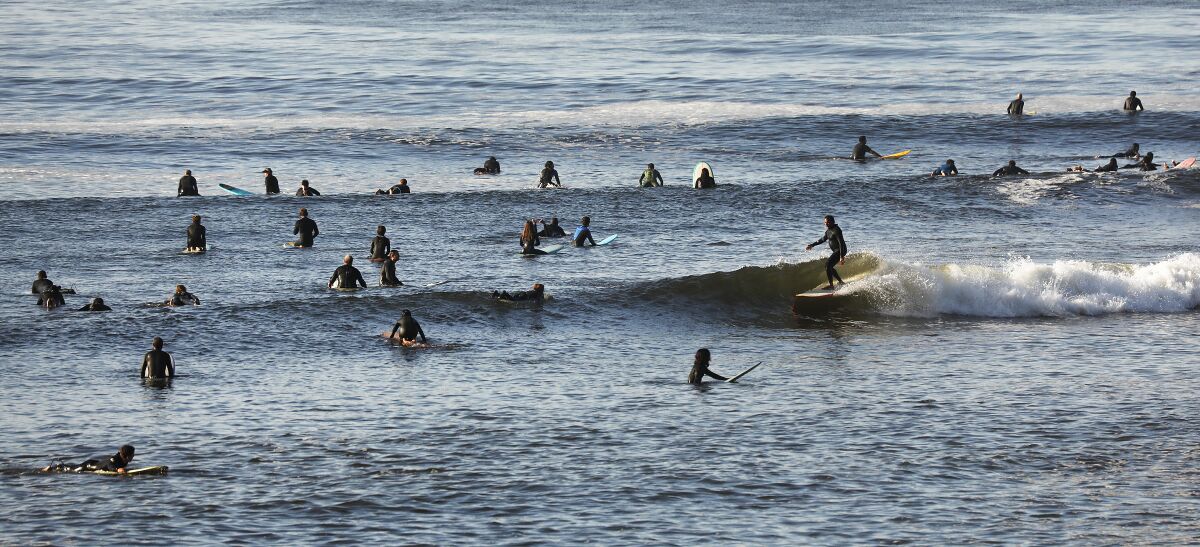 More than two dozen surfers in the ocean