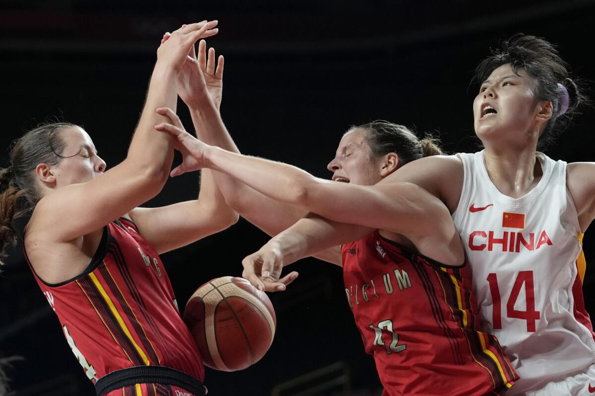China's Yueru Li (14) reached over Belgium's Jana Raman (42) as she battles for a rebound during a women's basketball game at the 2020 Summer Olympics, Monday, Aug. 2, 2021, in Saitama, Japan. (AP Photo/Eric Gay)