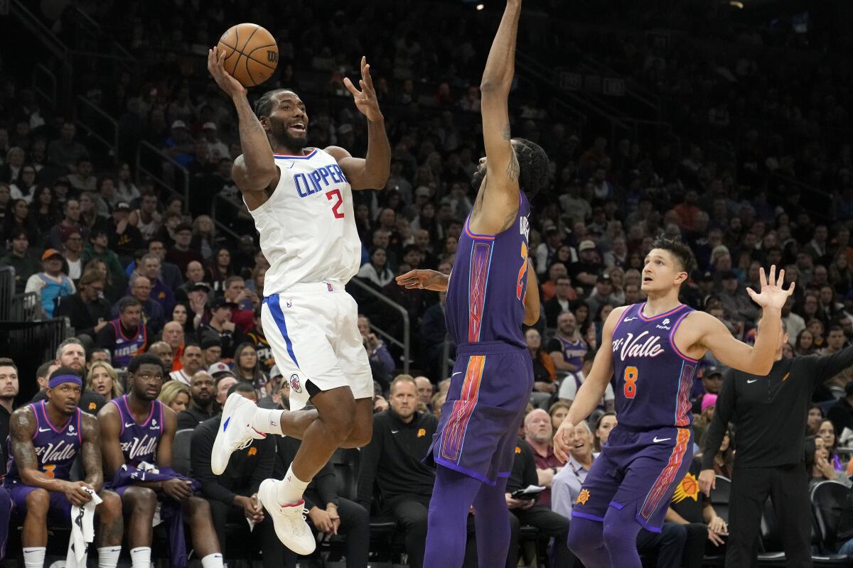 Clippers forward Kawhi Leonard is fouled as he goes up for a shot in front of Suns forward Keita Bates-Diop 