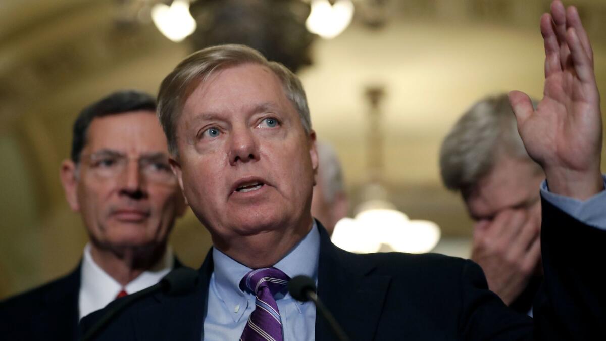 Sen. Lindsey Graham (R-S.C.) promotes his Obamacare repeal bill Tuesday as co-sponsor Sen. Bill Cassidy (R-La.), right, listens. At left is Sen. John Barrasso (R-Wyo.).