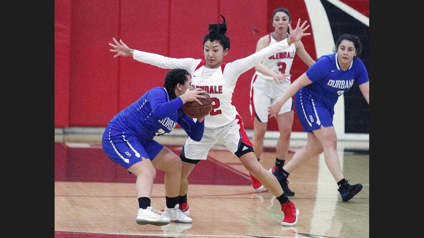 Glendale's Jillian Yanai spreads out wide on defense as Burbank's Emily Monterrey looks to pass in a Pacific League girls' basketball game at Glendale High School on Friday, January 5, 2018.