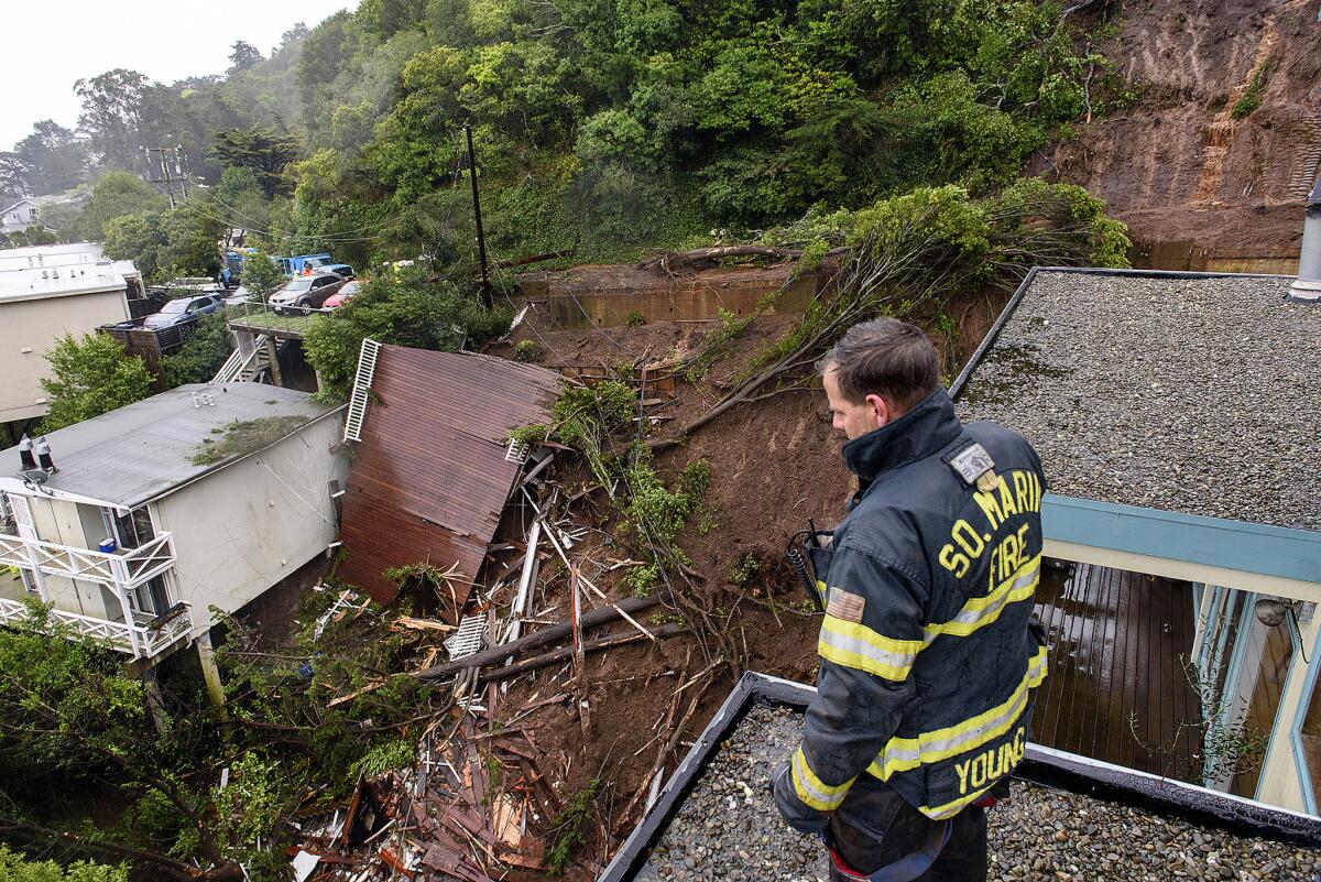 Patrick Young with the Southern Marin Fire Department looks out over the aftermath of a mudslide that destroyed three homes on a hillside in Sausalito.