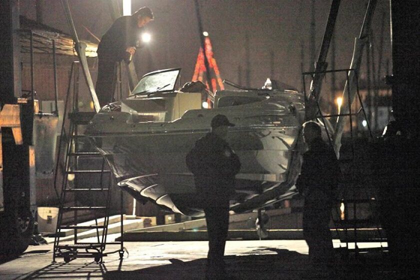 Law enforcement officials examine the pleasure boat struck by the Coast Guard boat on Dec. 20, 2009.
