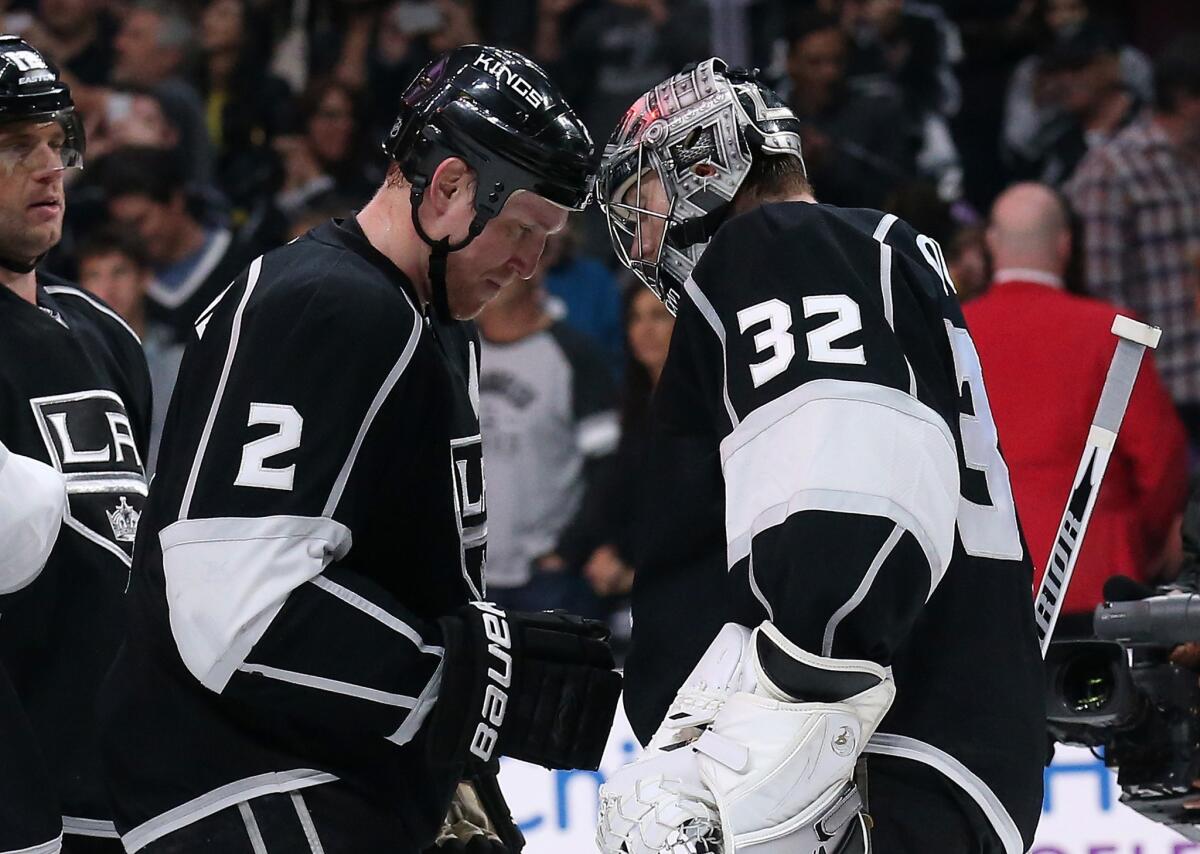 Kings goalie Jonathan Quick, right, and Matt Greene bump helmets as they celebrate a 3-1 win over the Colorado Avalanche on April 4.