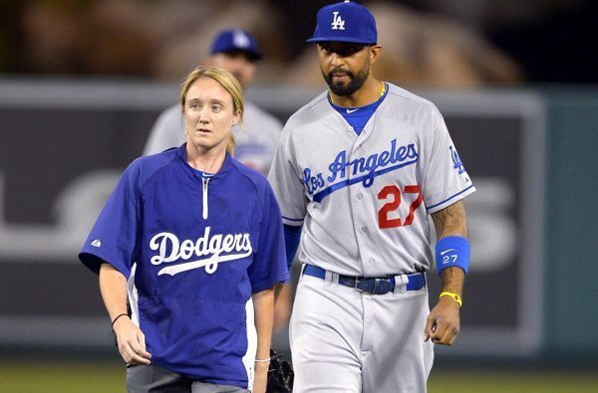 Dodgers center fielder Matt Kemp walks off the field with assistant trainer Nancy Patterson during the seventh inning of Wednesday night's game in Anaheim.