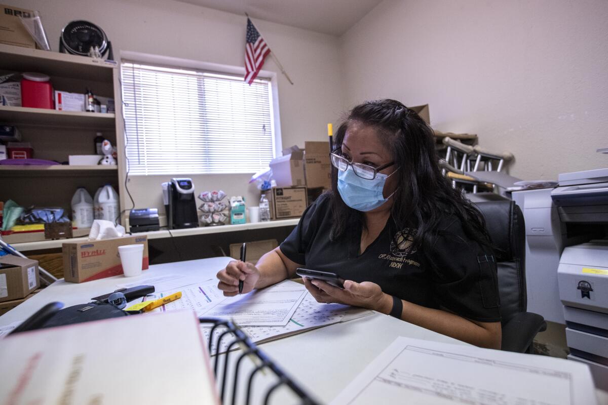 Contact tracer Marlene Montoya talks on the phone with a woman whose daughter is ill with COVID-19.