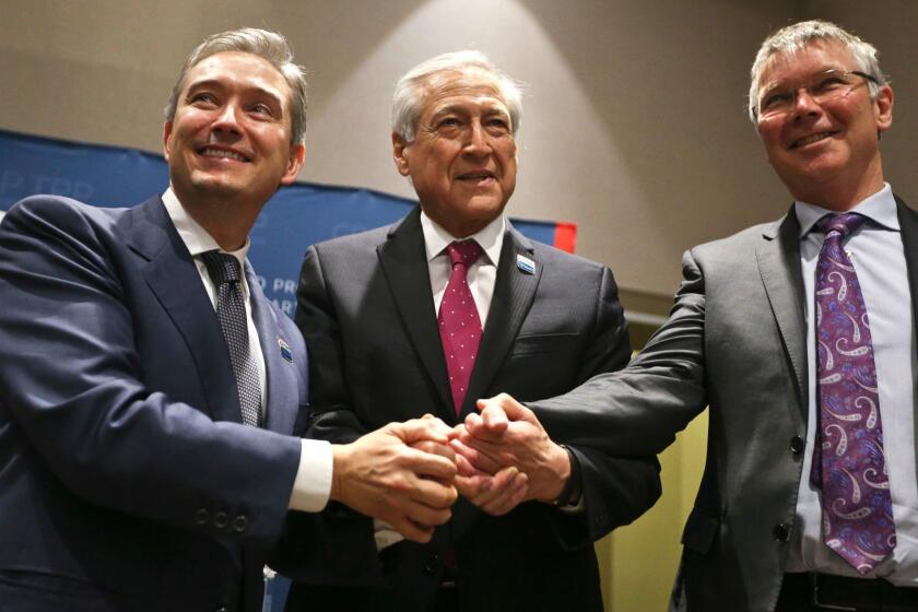 Canada's Minister of International Trade Francois-Philippe Champagne, Chile's Foreign Minister Heraldo Munoz and New Zealand's Trade Minister David Parker, pose for a photograpghers before a signing ceremony of the Comprehensive and Progressive Agreement for Trans-Pacific Partnership, CP-TPP, in Santiago, Chile, Thursday, March 8, 2018. (AP Photo/Esteban Felix)