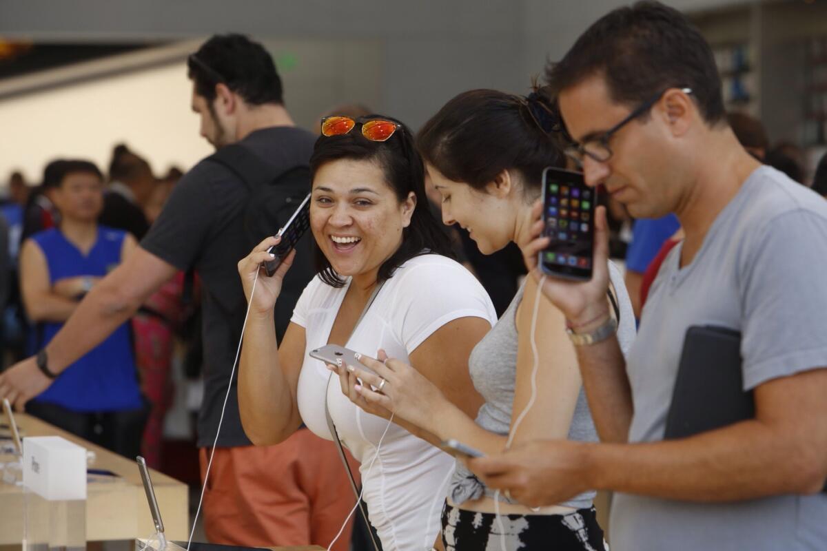 Erika Castillo, left, and Dan Unger, right, check out the iPhone 6 Plus at the Apple Store in Santa Monica on Friday.