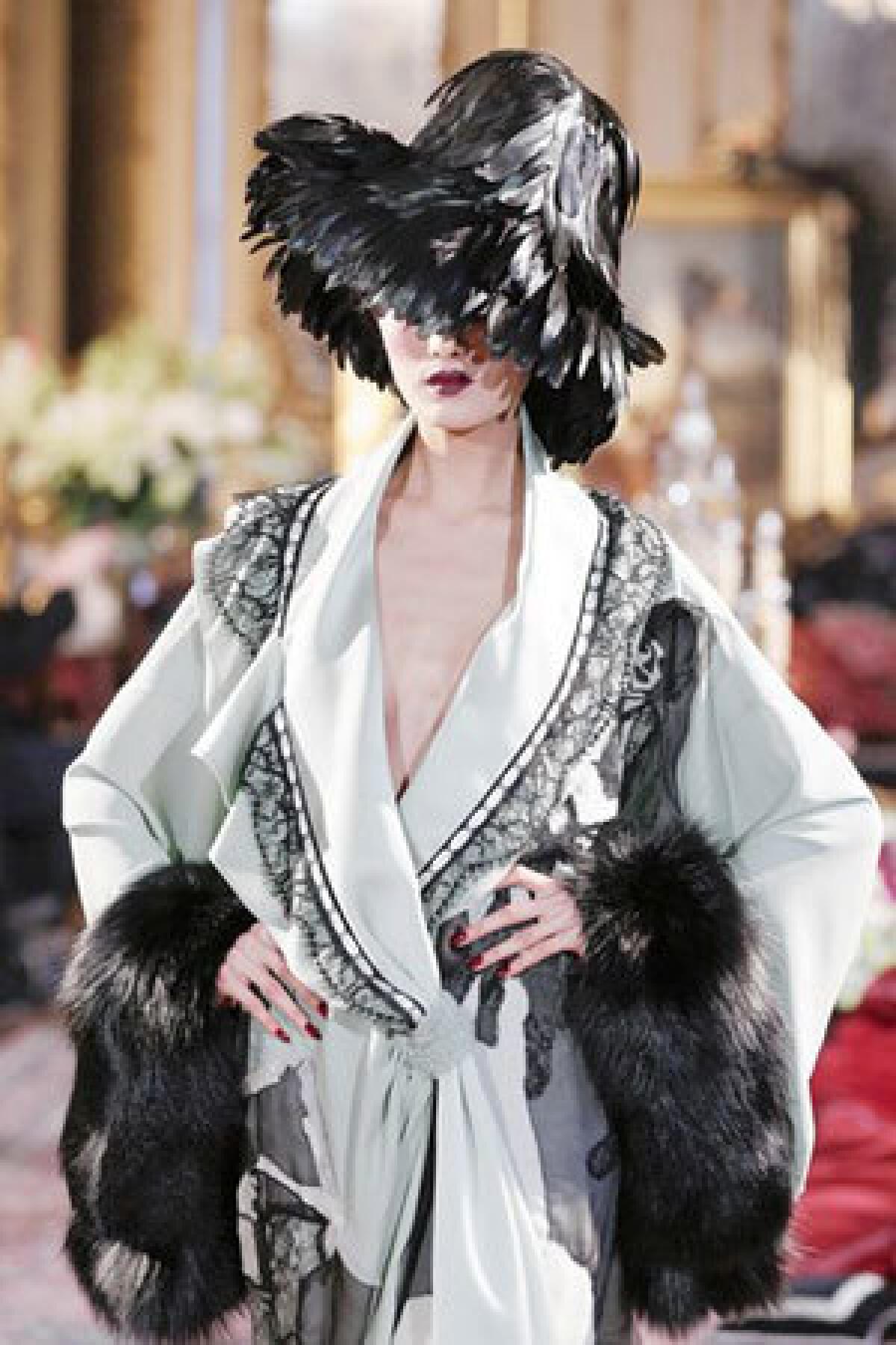 Galliano's collection included a lacy pale green kimono coat with fur trim.