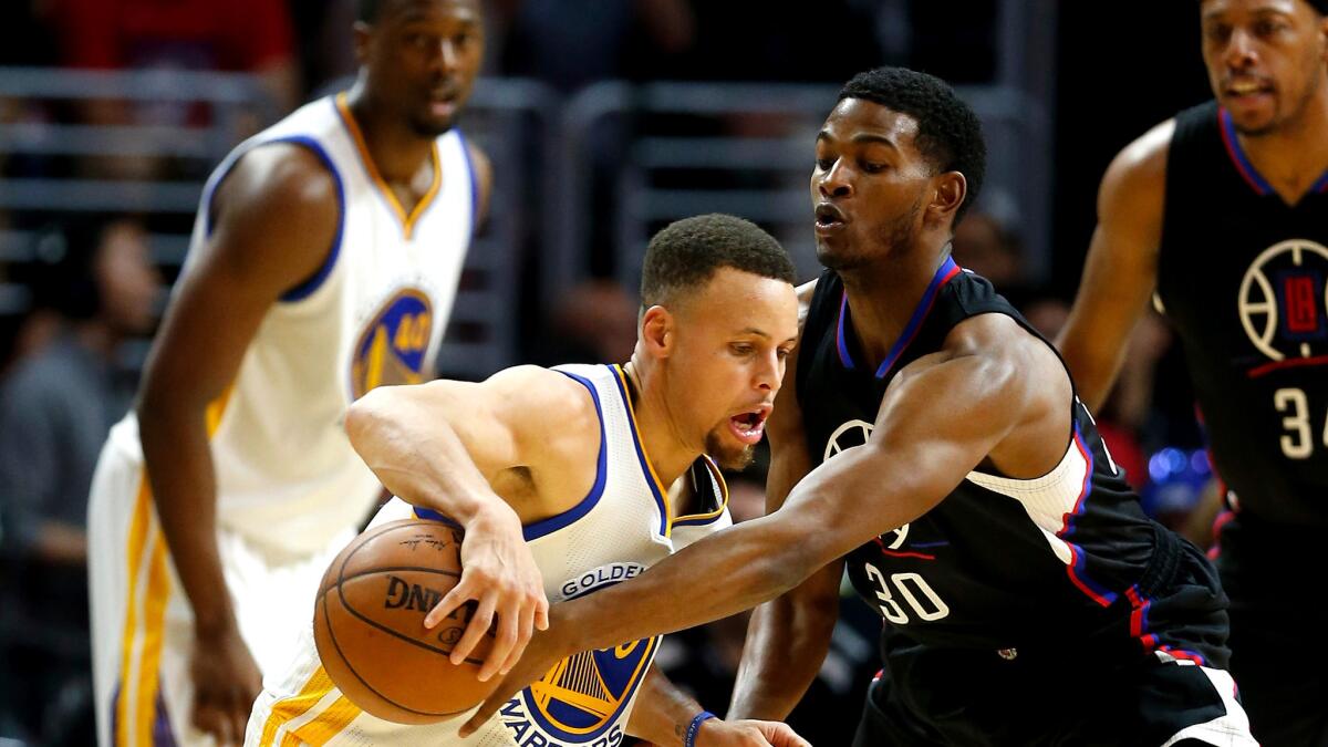 Clippers guard C.J. Wilcox (30) goes for a steal against Warriors guard Stephen Curry during the second half Saturday night.