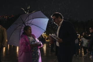 A candidate for Supreme Court Justice talks to a citizen during a campaign event