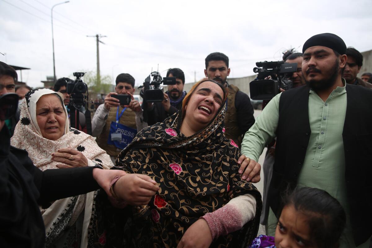 Afghans mourn near the scene of an attack March 25 in Kabul.