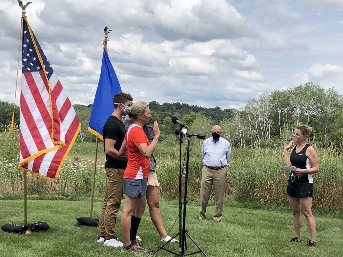 Wisconsin Supreme Court Justice Jill Karofsky is sworn in by fellow Justice Rebecca Dallet, right, as her children, Danny and Daphne, and former Gov. Jim Doyle look on. Karofsky took the oath Saturday, Aug. 1, 2020, in Basco, Wis., during a break in a 100-mile run. (Patrick Marley/Milwaukee Journal-Sentinel via AP)
