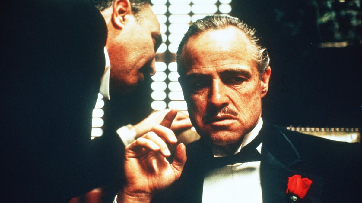 Salvatore Corsitto whispers to Marlon Brando in "The Godfather."