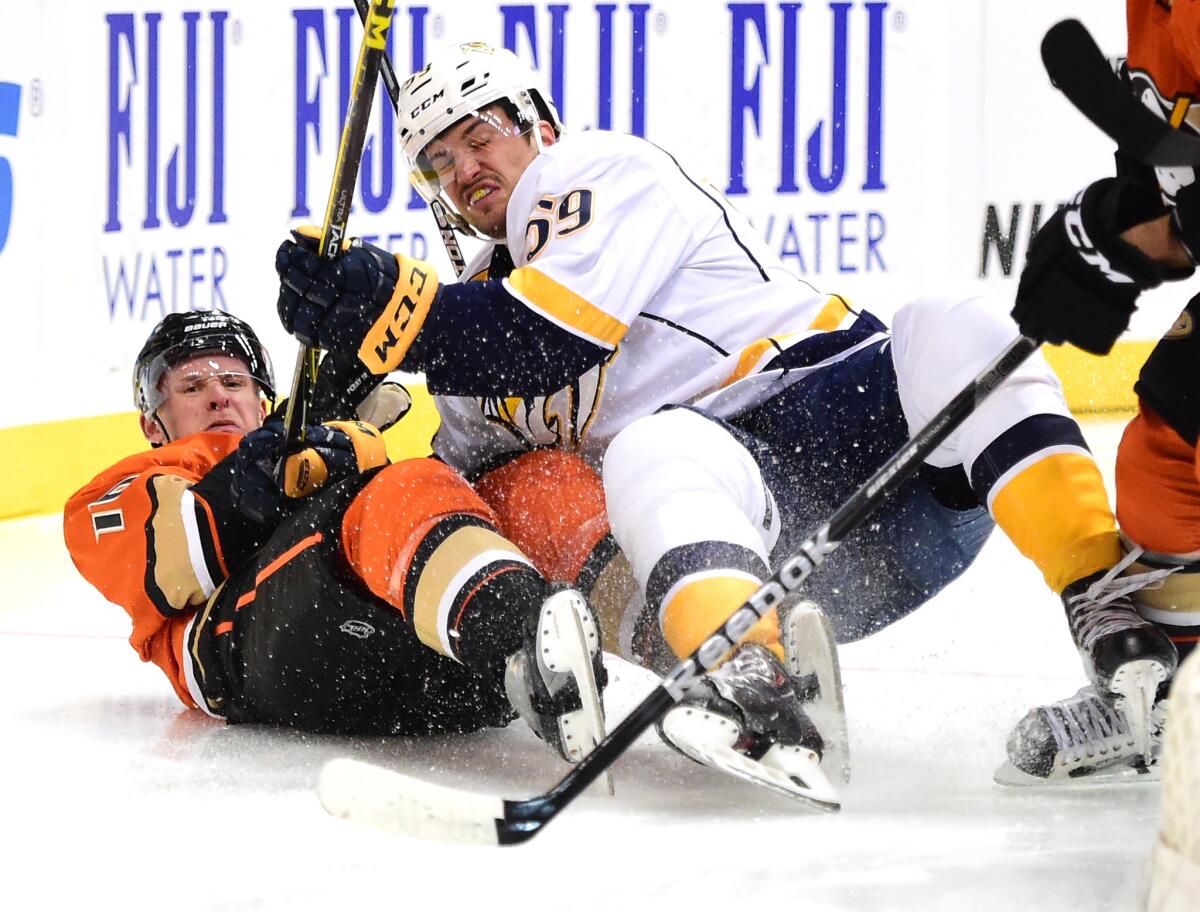Ducks forward Corey Perry (10) and Predators defenseman Roman Josi (59) fall to the ice during the first period on Nov. 1, 2015.