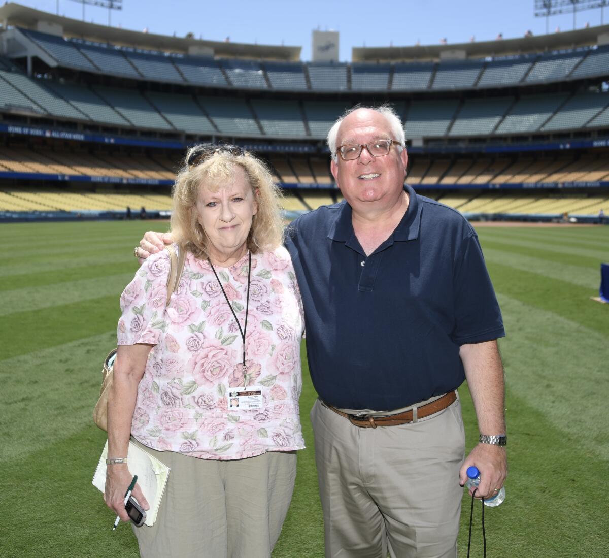 Dodgers official scorekeeper Dennis D'Agostino and his wife, Helene Elliott, stand together at Dodger Stadium.