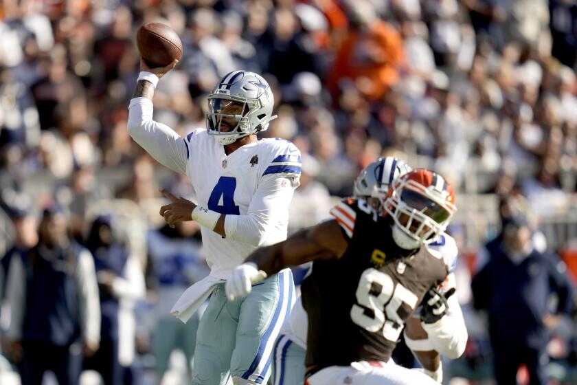 Dak Prescott (4), quarterback de los Cowboys de Dallas, lanza un pase bajo presión defensiva de Myles Garrett (95), defensive end de los Browns de Cleveland, en la primera mitad del juego de la NFL en Cleveland, el domingo 8 de septiembre de 2024. (AP Foto/Sue Ogrocki)