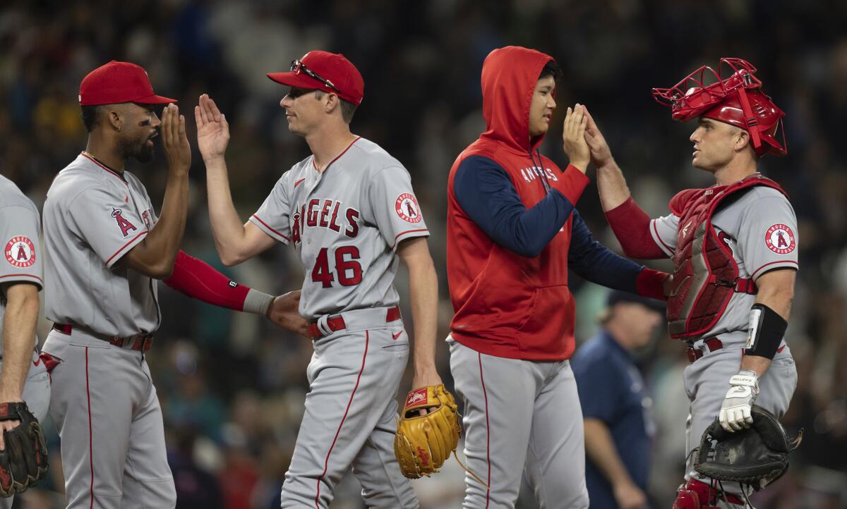 Angels players Jo Adell, Jimmy Herget, Shohei Ohtani and Max Stassi celebrate after their 4-3 win in 10 innings.