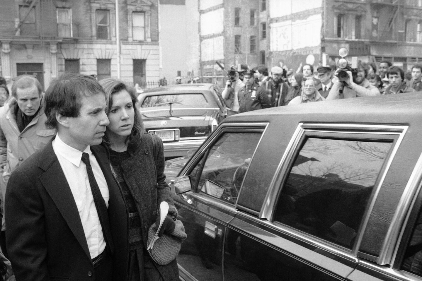 Singer-composer Paul Simon and actress Carrie Fisher leave the Cathedral of St. John the Divine in New York City, after a memorial service for comedian John Belushi.