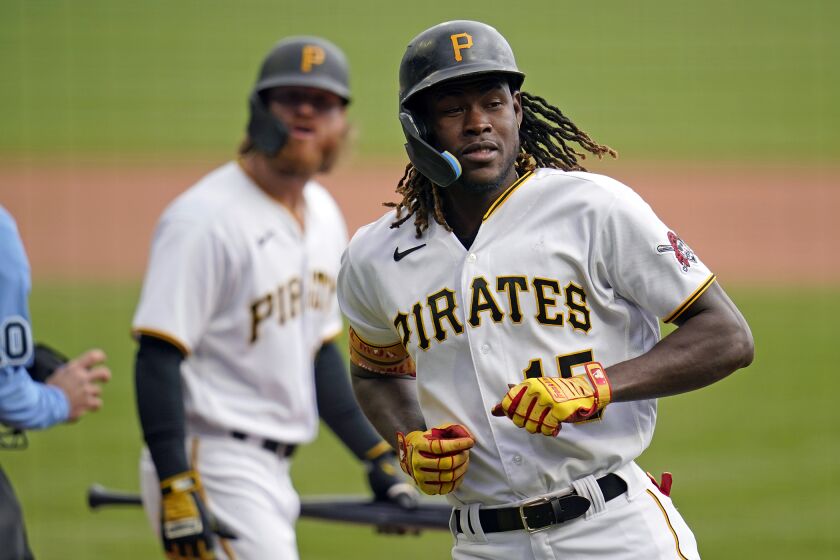 Pittsburgh Pirates' Oneil Cruz, right, returns to the dugout after scoring on an RBI double by Miguel Andujar off Cincinnati Reds starting pitcher Luis Cessa during the first inning of a baseball game in Pittsburgh, Wednesday, Sept. 28, 2022. (AP Photo/Gene J. Puskar)