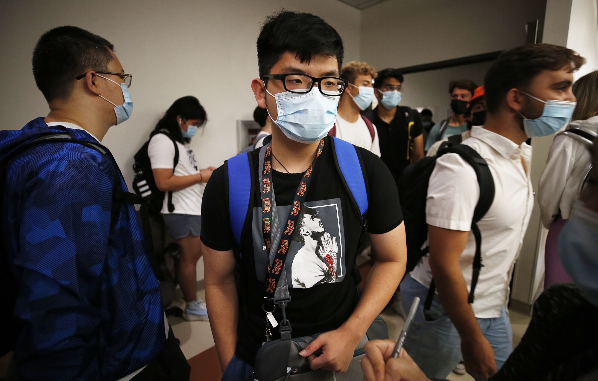 Sophomore student Khoa Nguyen waits with other students to enter a classroom on the USC campus.