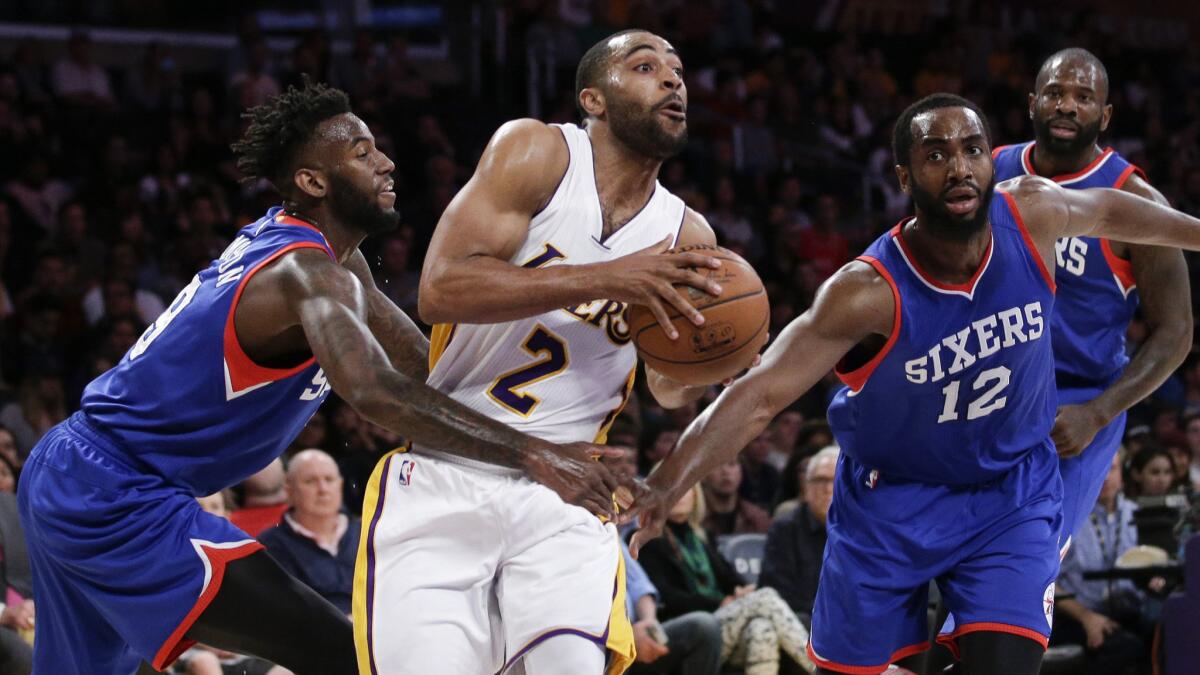 Lakers guard Wayne Ellington, center, looks to pass between Philadelphia 76ers teammates JaKarr Sampson, left, and Luc Mbah a Moute during the Lakers' win at Staples Center on March 22.