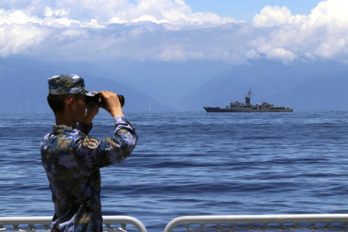 Chinese soldier looking out at Taiwanese frigate
