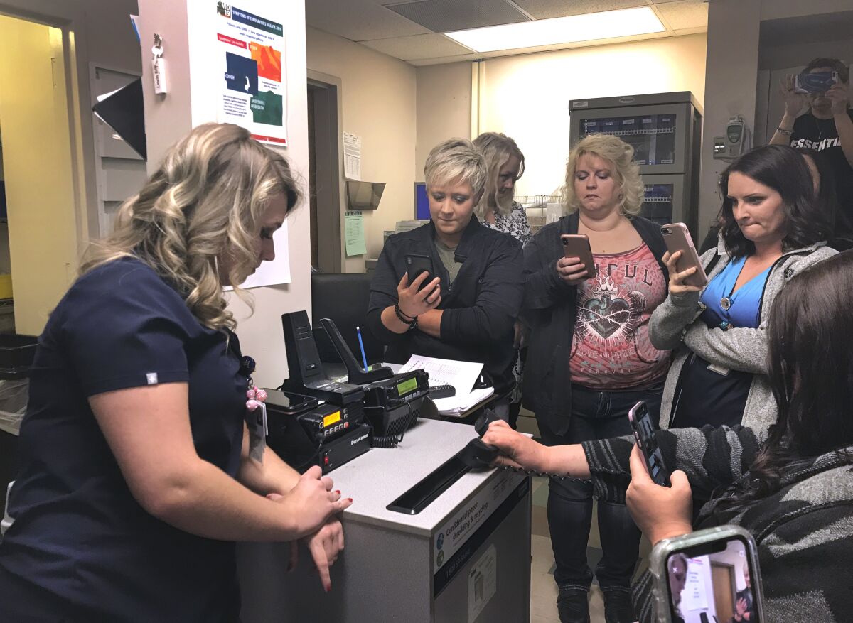 Williamson Memorial Hospital staff huddle in the nurses station for a ceremonial last call from the emergency dispatcher.