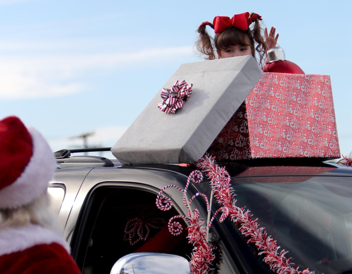 Santa Claus gets a shy wave from Brianna Johansen, 7, 