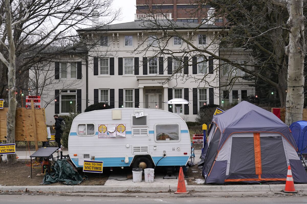 FILE - Jon Vaughn's small blue-and-white camper, which has been parked outside the home of the University of Michigan's president since early October is seen on Jan. 20, 2022, has been removed, Vaughn says. The former star running back for the university's Wolverines football team set up the camp to protest the sexual abuse he and more than 1,000 other students say they suffered at the hands of the university's late sports doctor Robert Anderson. (AP Photo/Paul Sancya File)