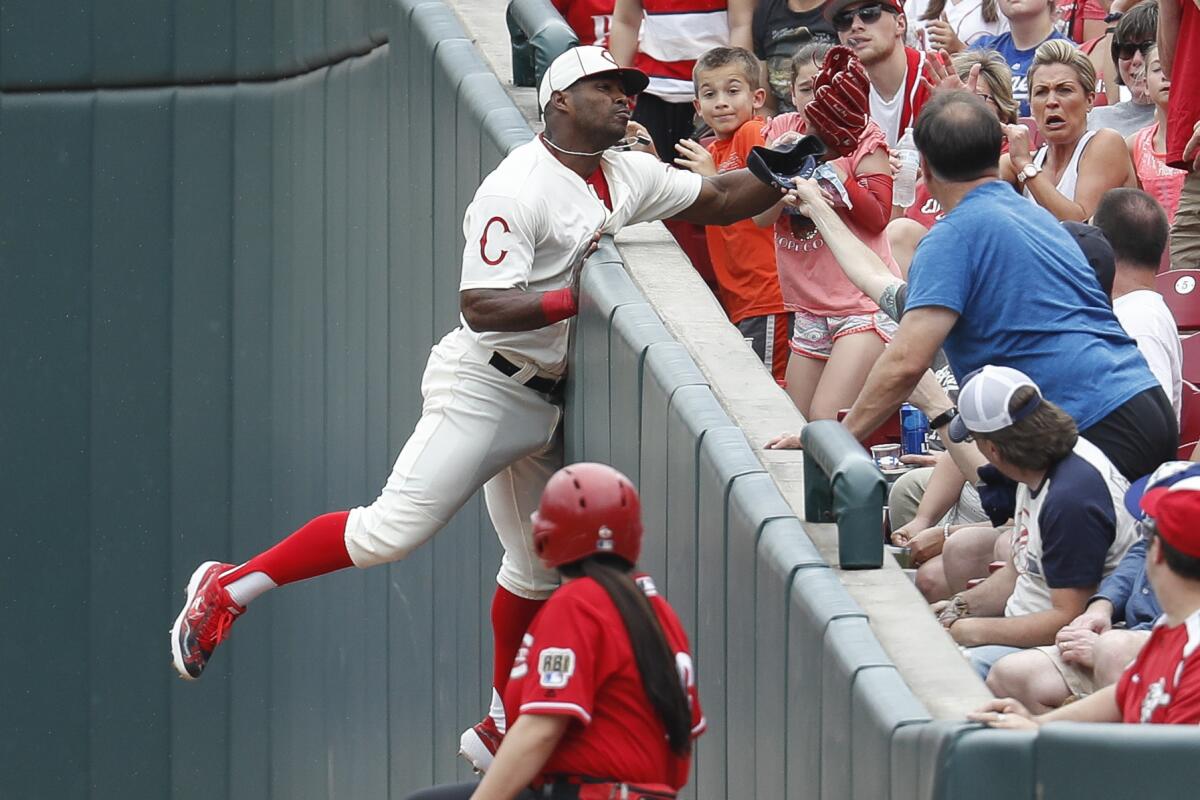 Cincinnati Reds' Yasiel Puig catches a foul ball hit by Los Angeles Dodgers' Hyun-Jin Ryu.