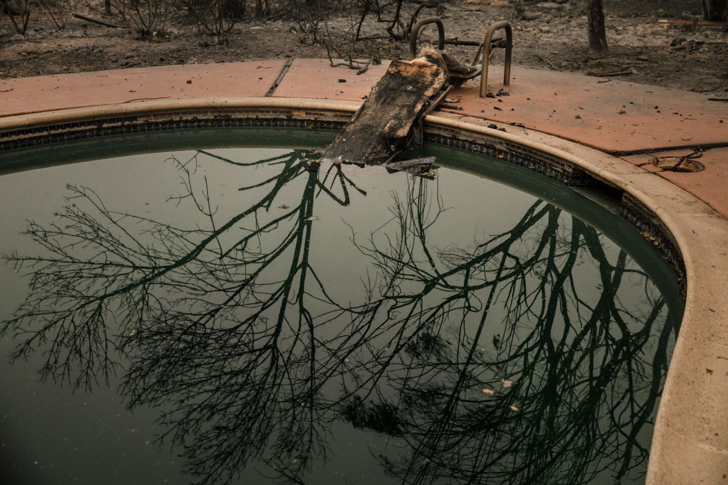 A swimming pool reflects the damage caused by the wildfires that moved through neighborhoods near Glen Ellen.