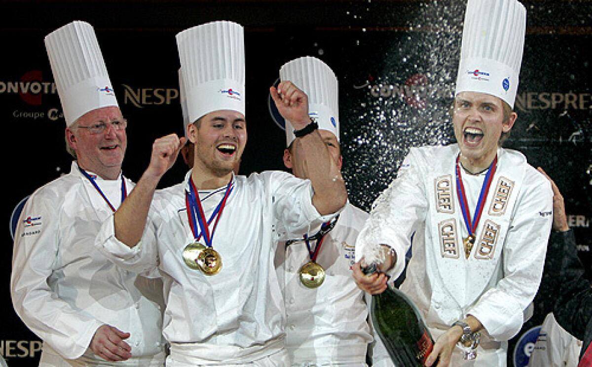 Norway's chef Geir Skeie, right, celebrates on the podium with his teammates after winning the "Bocuse d'Or" (Golden Bocuse) trophy, at the 12th World Cuisine contest, in Lyon, central France, Wednesday, Jan. 28.