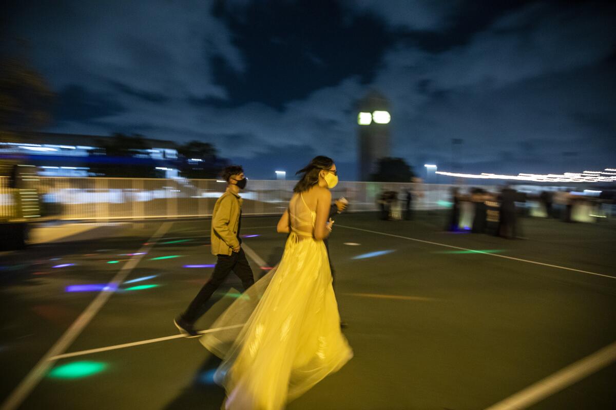 Two people walk across a dancefloor. 