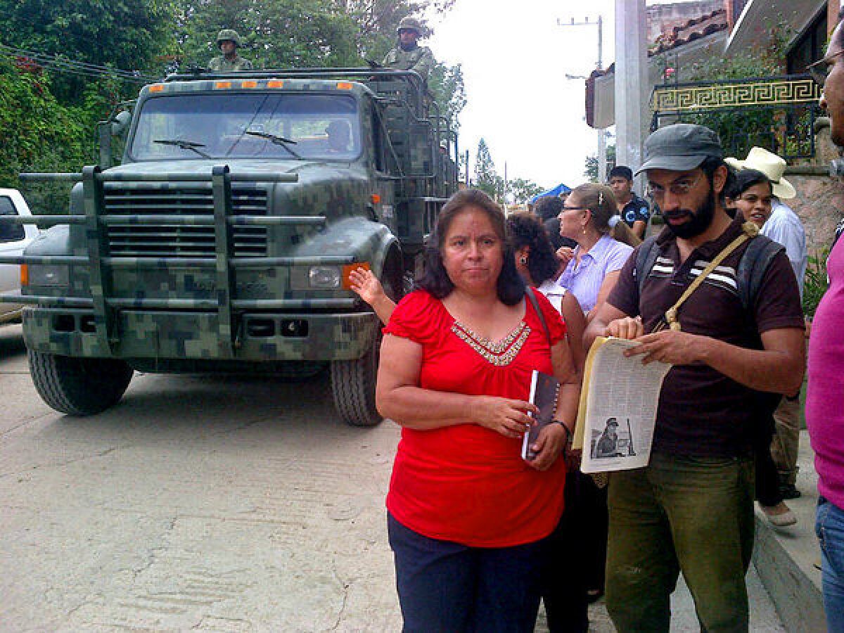A Mexican army truck rolls by minutes before townspeople in Olinala, including Nestora Salgado's sister Cleotilde, meet to discuss Salgado's case.
