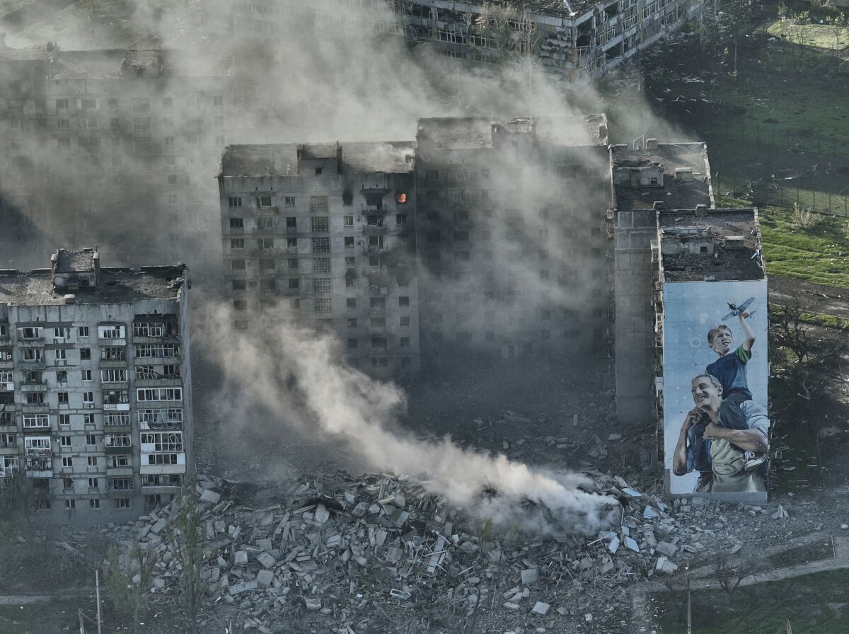 FILE - Smoke rises from a building in Bakhmut, the site of the heaviest battles with the Russian troops in the Donetsk region, Ukraine, Wednesday, April 26, 2023. Ukrainian President Volodymyr Zelenskyy said Sunday, May 21, 2023 that Russian forces weren't occupying Bakhmut, casting doubt on Moscow's insistence that the eastern Ukrainian city had fallen. The fog of war made it impossible to confirm the situation on the ground in the invasions longest battle, and the comments from Ukrainian and Russian officials added confusion to the matter. (AP Photo/Libkos, File)