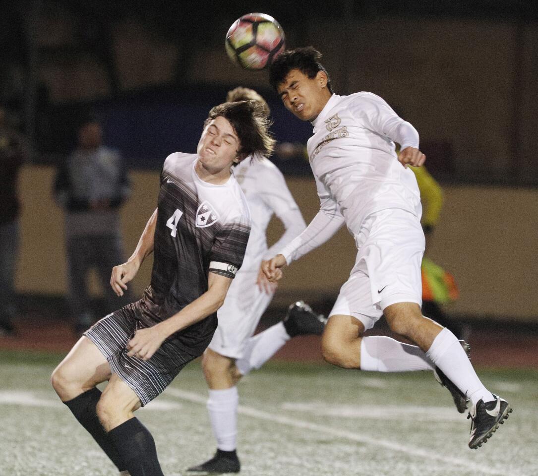 St. Francis' defender Samir Sheikh heads the ball away from Crespi's Daniel Law in a boys' soccer game at Crespi High School in Encino on Wednesday, January 9, 2019. The game ended in a tie, 1-1