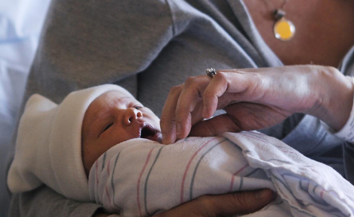 Jennie Keane sostiene a su hija, Clare Elizabeth Keane. Cifras preliminares reveladas por el gobierno muestran que los nacimientos aumentaron en EEUU durante 2014 por primera vez en siete años.