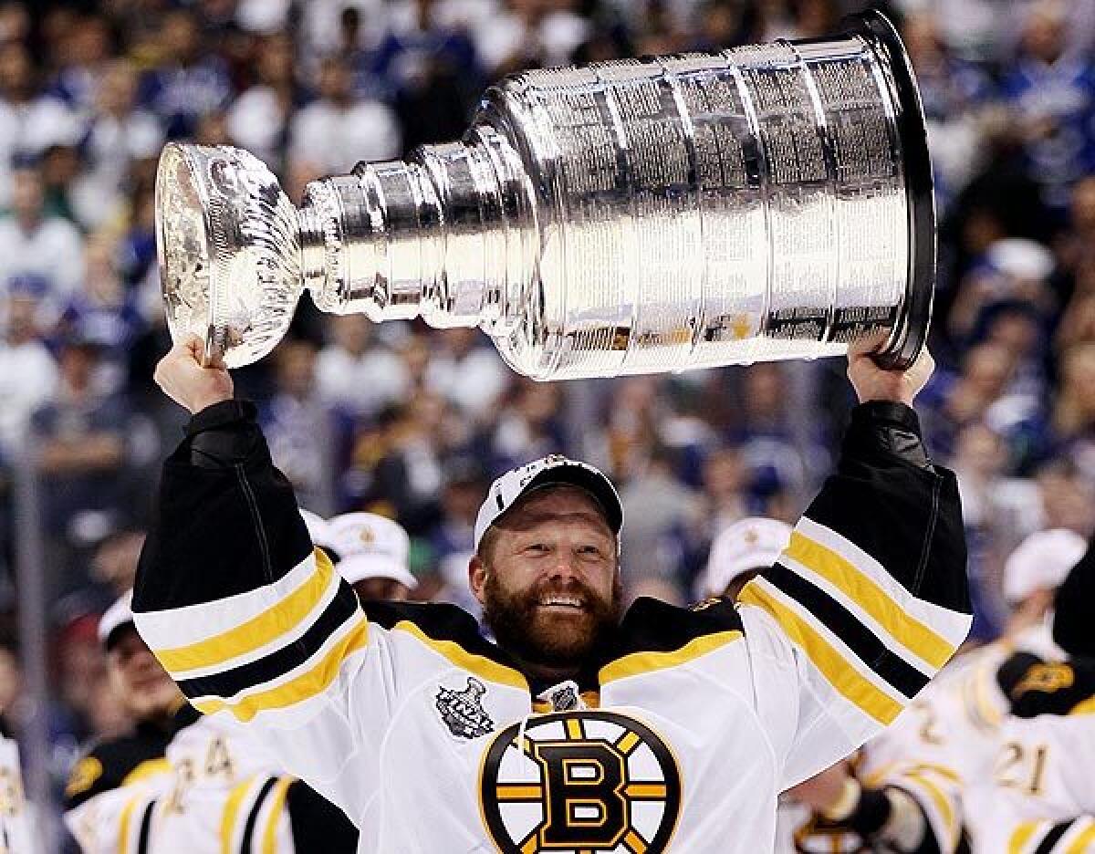 Bruins goaltender Tim Thomas hoists the Stanley Cup following the Bruins' 4-0 victory over the Canucks in Game 7 of the 2011 Stanley Cup Final.
