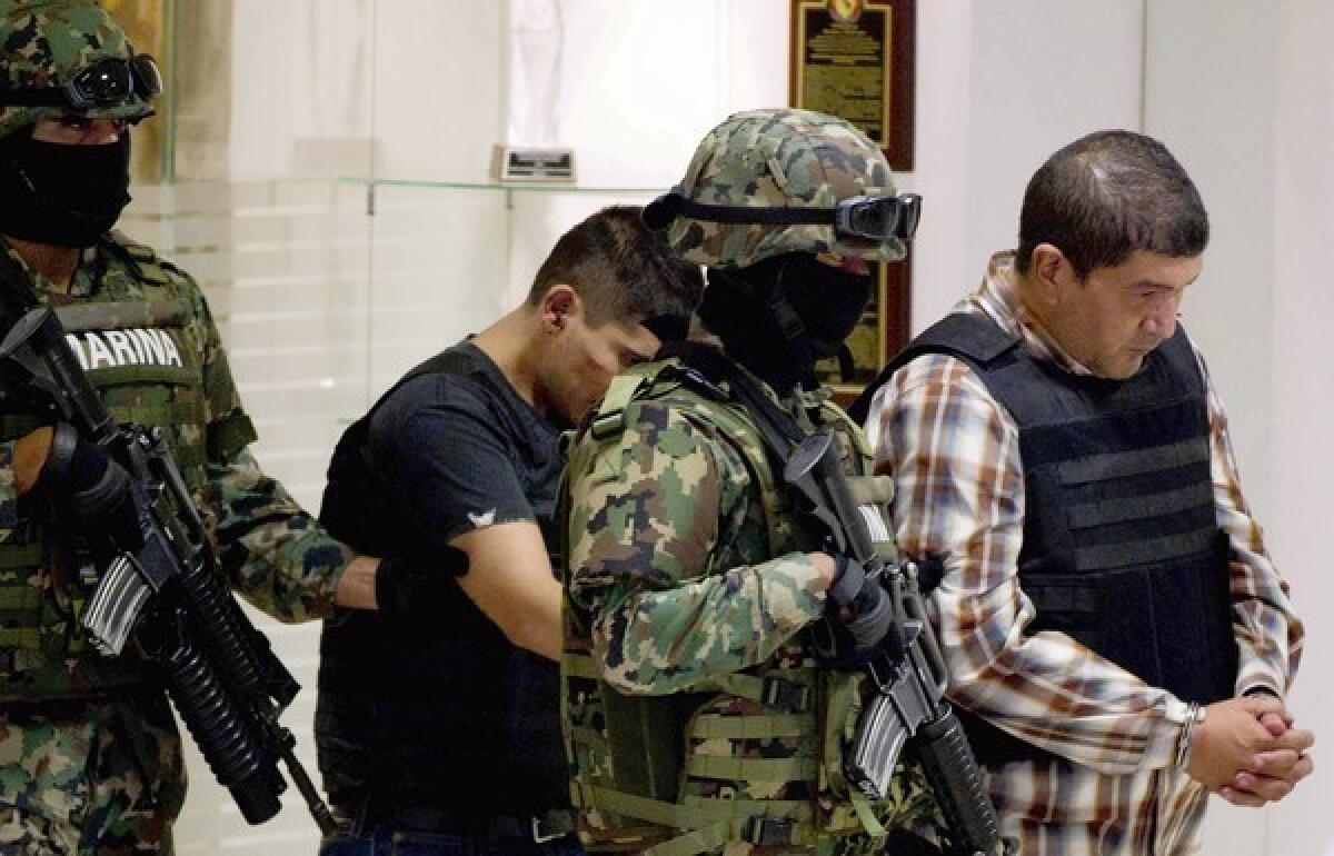 Ivan Velazquez Caballero, right, is escorted to a news conference in Mexico City a day after his arrest.