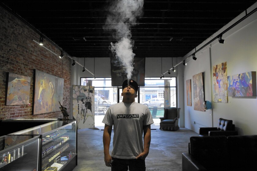 Owner Patrick Sanchez smokes an electronic cigarette at Vapegoat in Highland Park. Lawmakers have moved to ban the use of e-cigarettes in public places where smoking is already prohibited.