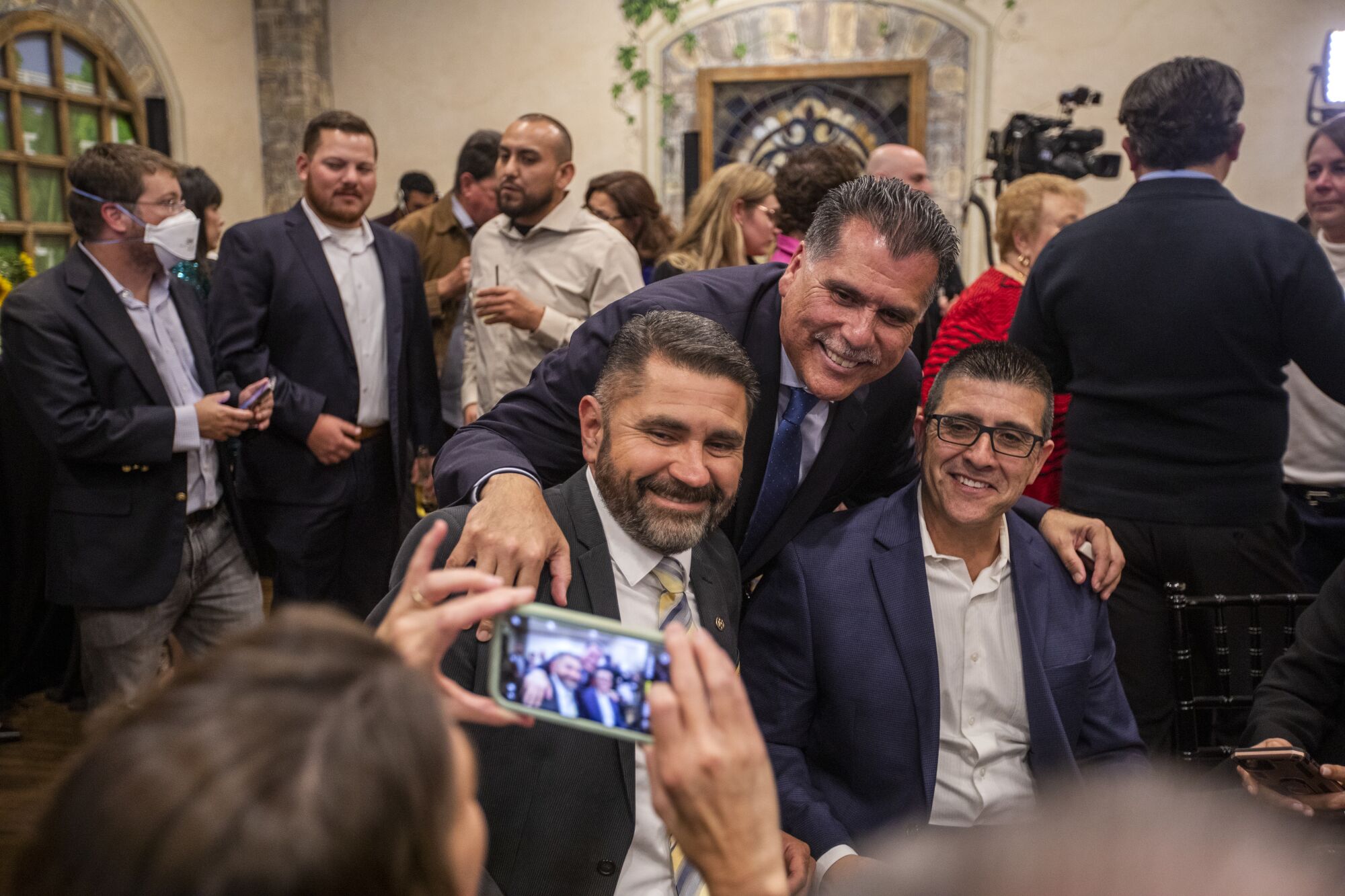 Robert Luna, middle, is photographed with supporters during election night in Long Beach.