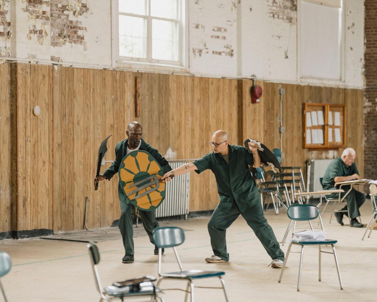 Two men playing with prop swords and shields.