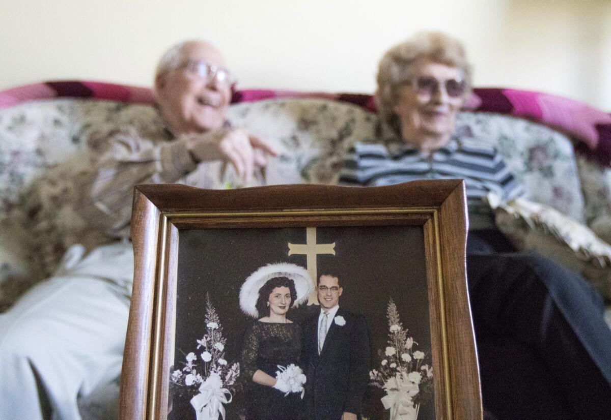 A husband and wife's 58-year-old wedding photo is seen in the foreground while they reminisce about their marriage at their home in Sycamore, Ill. on Feb. 10.