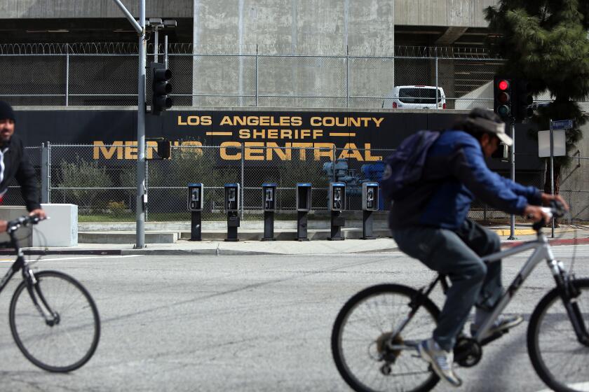 LOS ANGELES, CA-MARCH 24, 2020: Bicyclers pass the Men's Central Jail on March 24, 2020 in Los Angeles, California. Los Angeles County Supervisor Kathryn Barger signed an executive order that clears the way for the Sheriff's Department to release more inmates amid concerns that the coronavirus will enter the nation's largest jail system. (Photo By Dania Maxwell / Los Angeles Times)