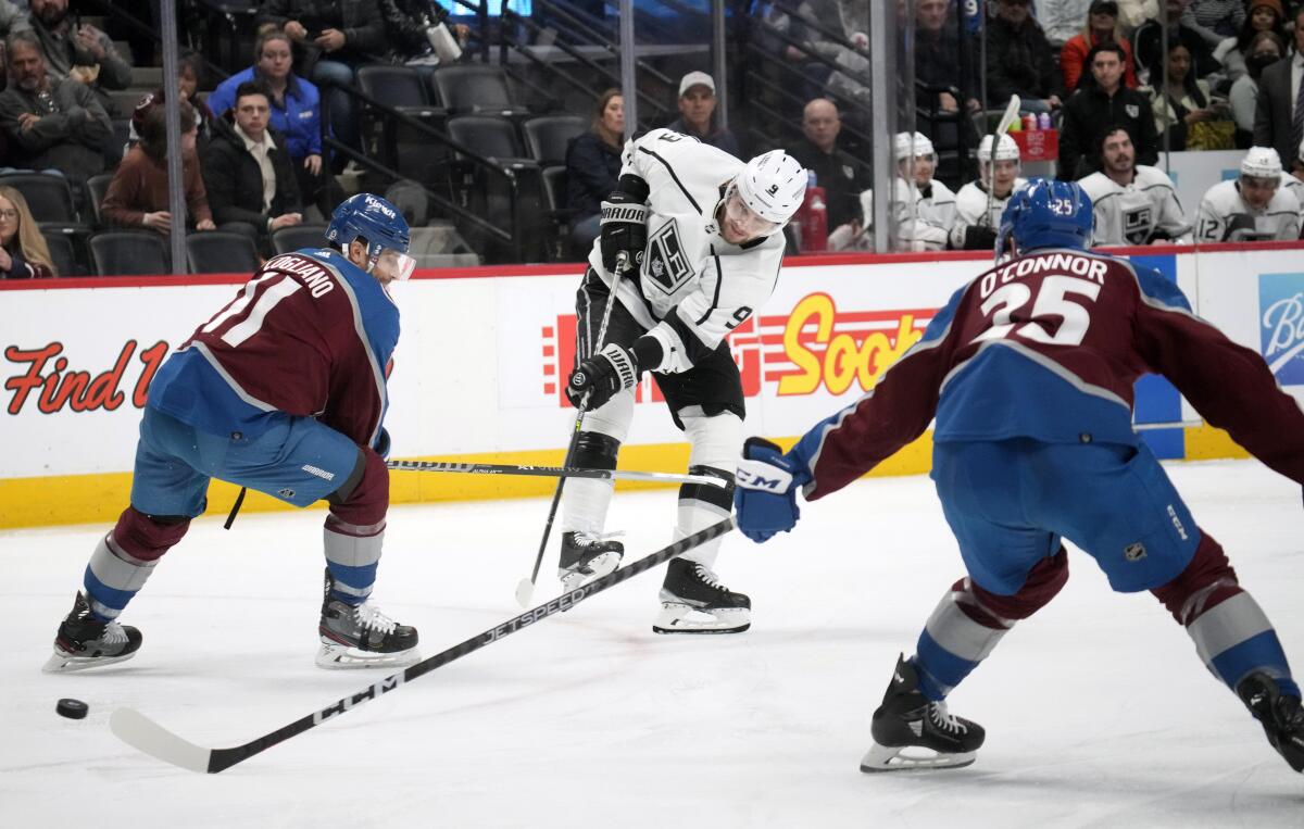 Kings right wing Adrian Kempe fires the puck between Colorado Avalanche center Andrew Cogliano and right wing Logan O'Connor.