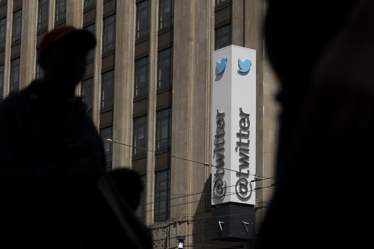 FILE - This July 9, 2019, file photo shows pedestrians walking across the street from the Twitter office building in San Francisco. The Saudi government recruited two Twitter employees to get personal account information of their critics, prosecutors said Wednesday, Nov. 6, 2019. (AP Photo/Jeff Chiu, File)