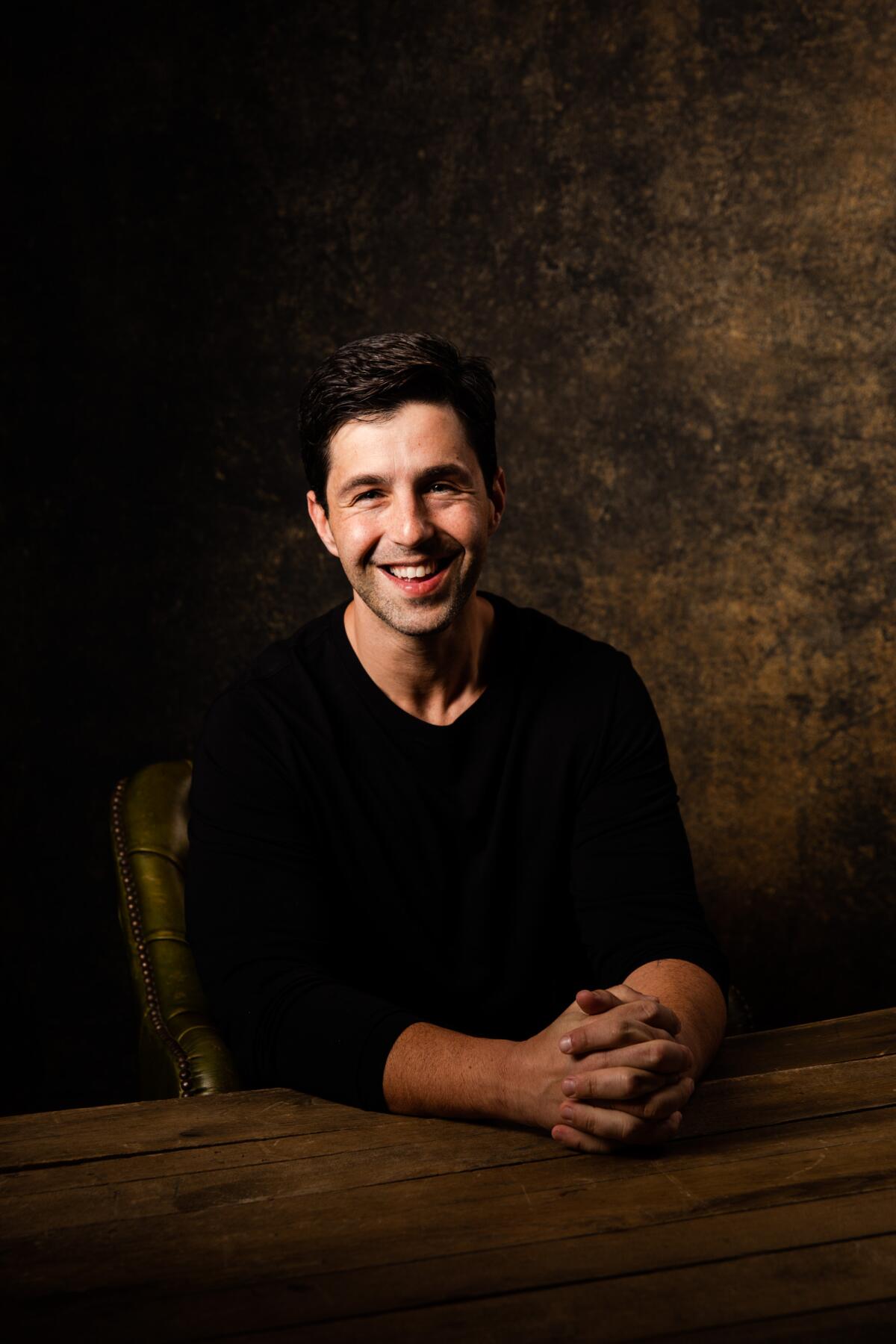 Josh Peck smiles in a studio portrait.