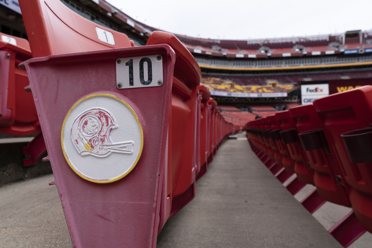The former logo for the Washington football team is seen on the sides of the seats before an NFL football practice at FedEx Field, Monday, Aug. 31, 2020, in Washington. (AP Photo/Alex Brandon)